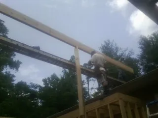 Carpenter setting a ridge beam over a new addition frame — Ice Dam Removal by Roofing Brothers in Martins Ferry
