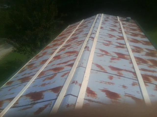 Rusted metal roof panels with new wood purlins before replacement — Storm Damage Roof Repair in Martins Ferry by Roofing Brothers