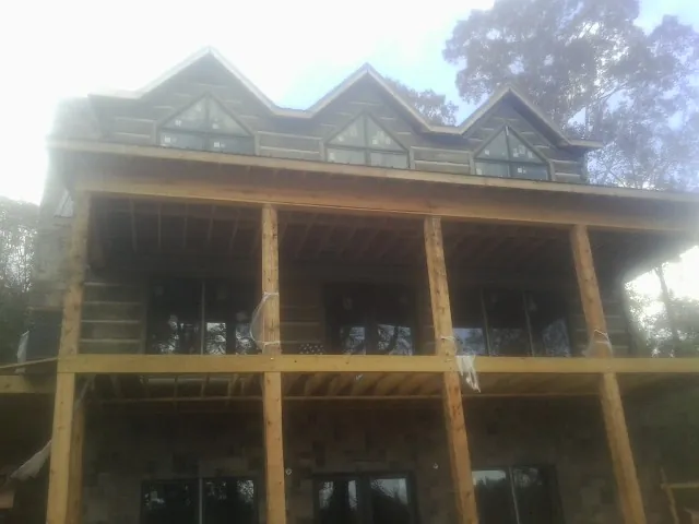 Dormers and porch framing on a large log home under construction — Roof Coating work by our crew in Martins Ferry