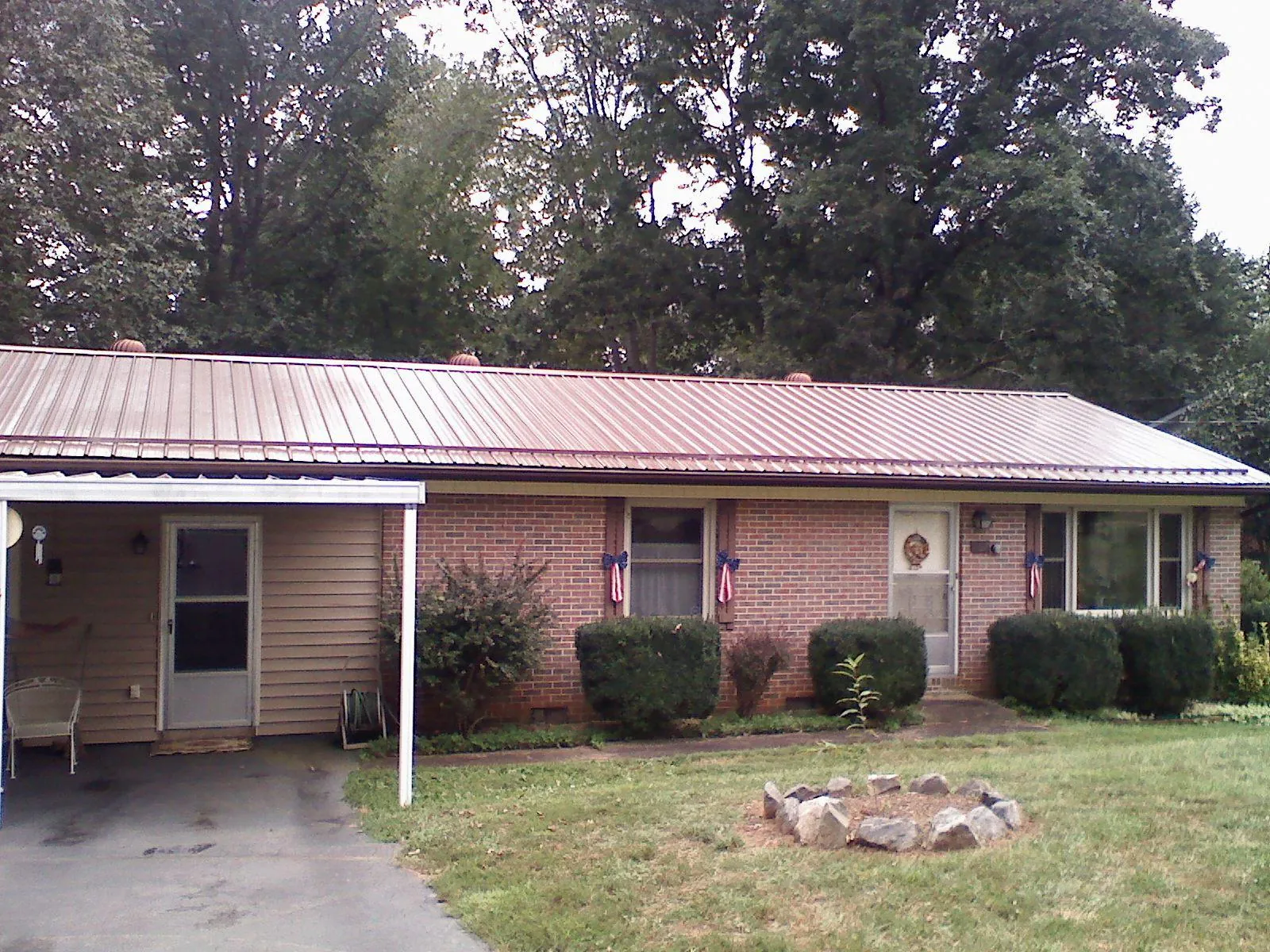 Bronze metal roof and carport on a brick ranch home — Roof Repair work by our crew in Martins Ferry